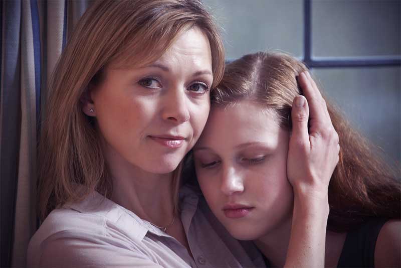mother hugging teenage daughter