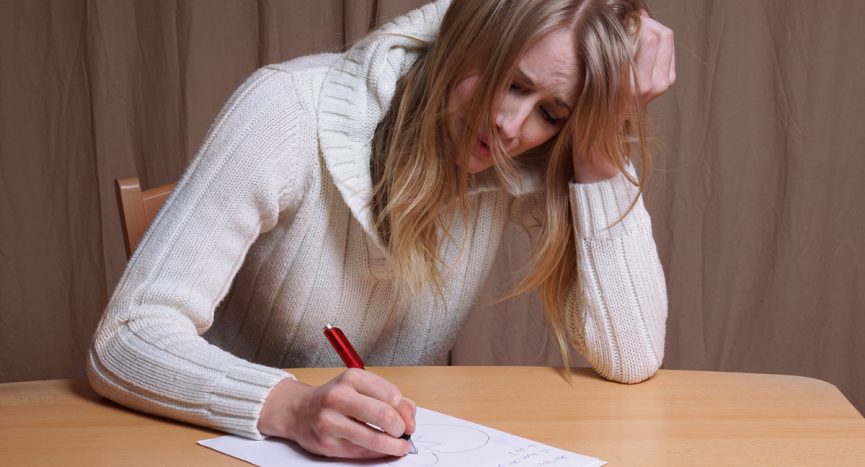 lovesick young woman writing letter with broken heart