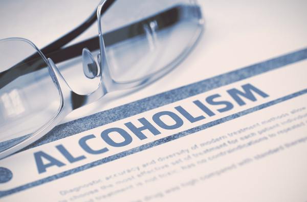 Pair of glasses on a document that has the word alcoholism on it.