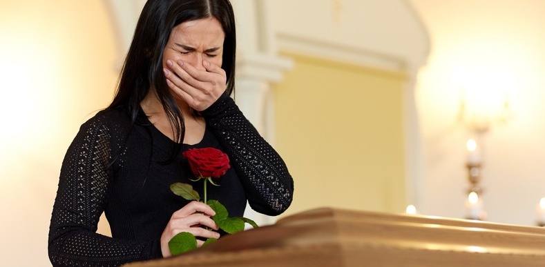Woman crying over a casket
