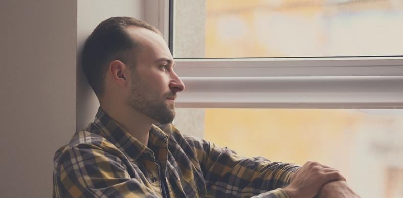 Man sitting in a window looking out