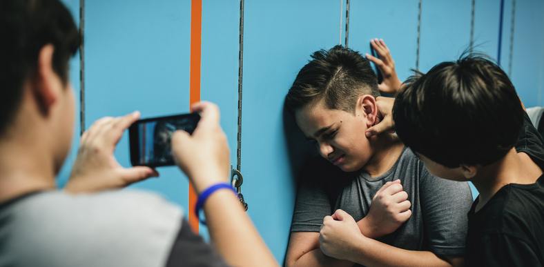 two teenage boys bullying another
