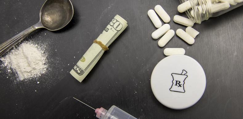 Tabletop with pills, dollar bills, and syringe