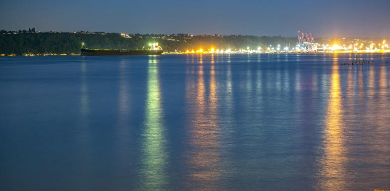 River at night with lights along the bank.