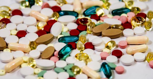 Pile of various pills on a table top.