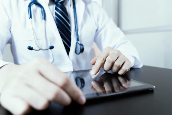 Medical doctor looking at a tablet.