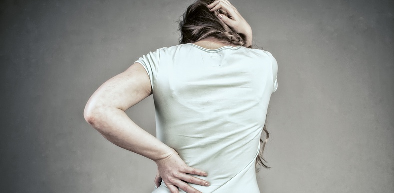 woman holding her back in pain
