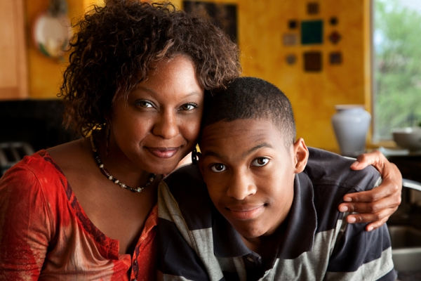 Mother with arm around son.