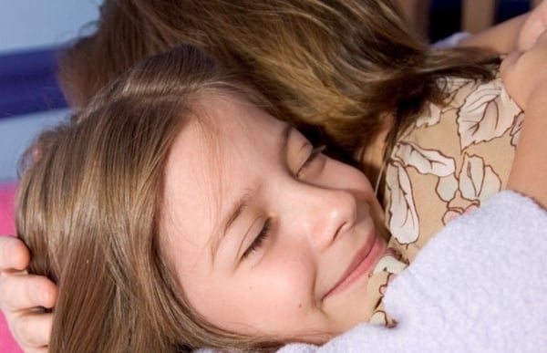 A young girl hugging a woman