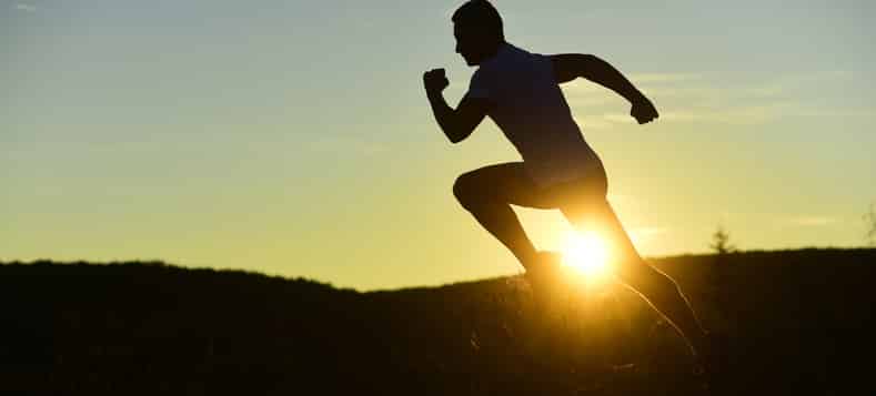 Man running with the sun setting in the background.