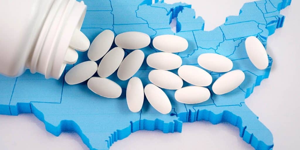 A bottle of pills spilling over the United States to represent the opioid crisis