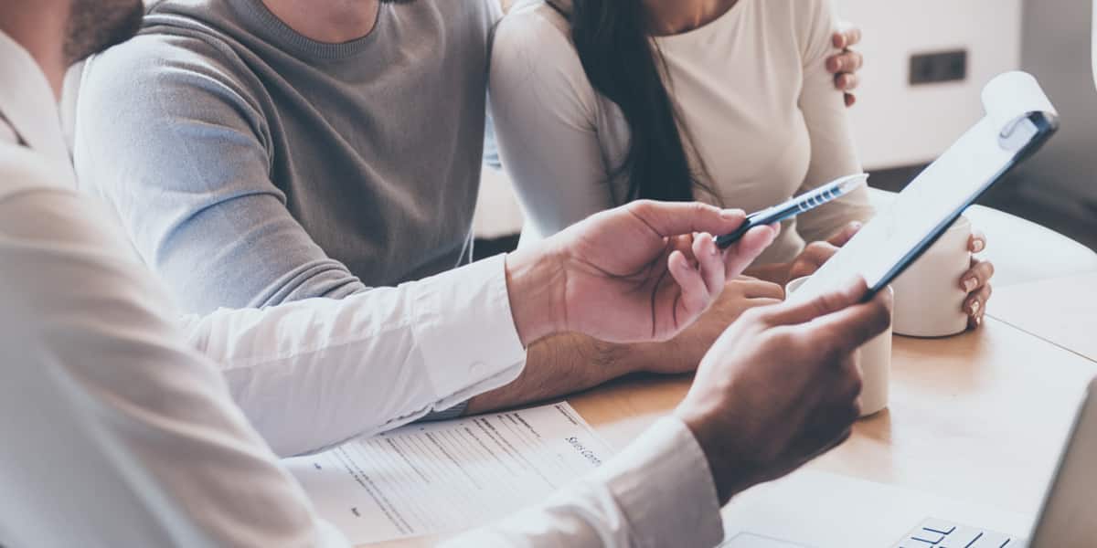 An insurance representative speaks to a couple about pricing for addiction treatment