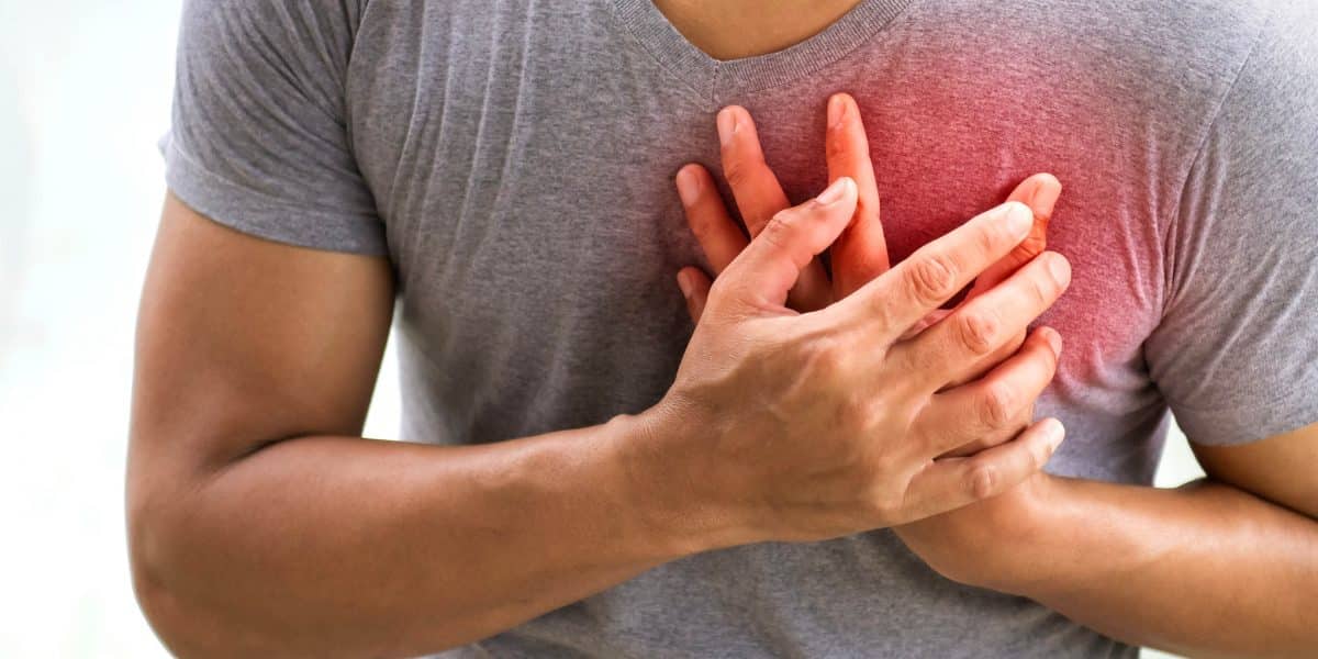 man gripping his chest after overdosing on amphetamines