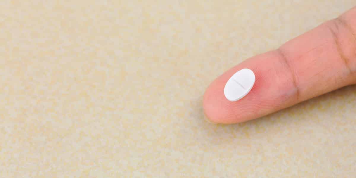 person holding benzodiazepine pill on their finger tip