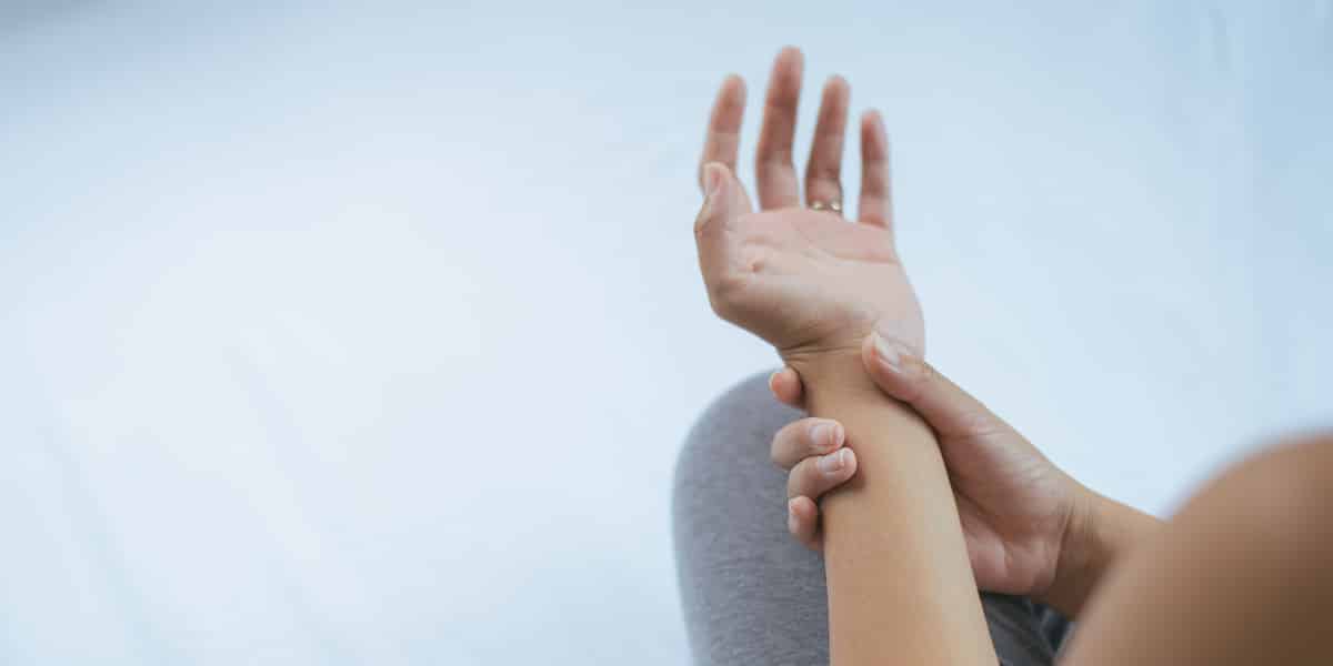 person experiencing DT tremors holding shaking arm