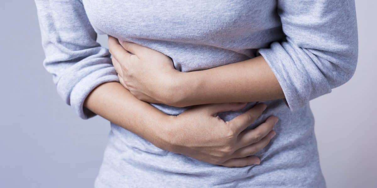 Person clenching their stomach while experiencing a fioricet overdose