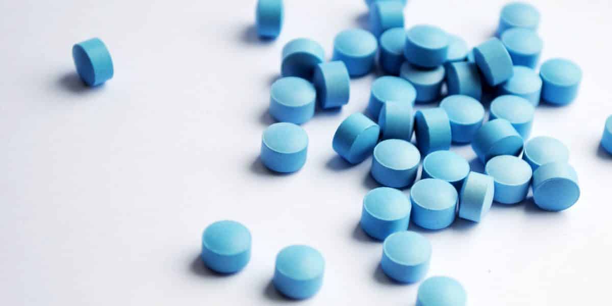 A pile of blue benzodiazepine pills on a white counter