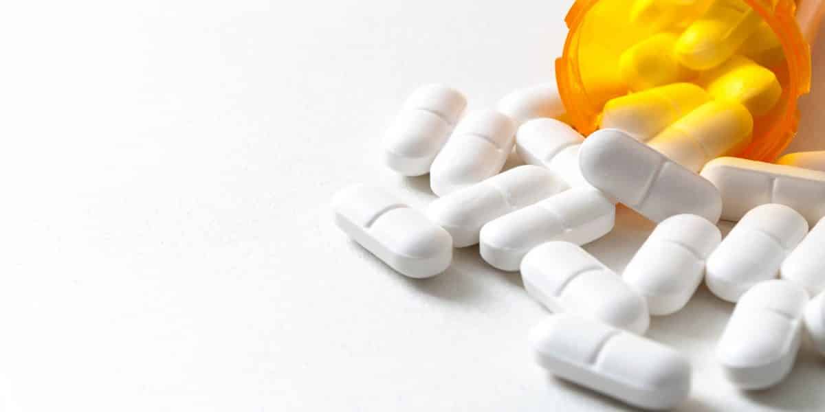 Opioid pills spilling out of a prescription pill bottle