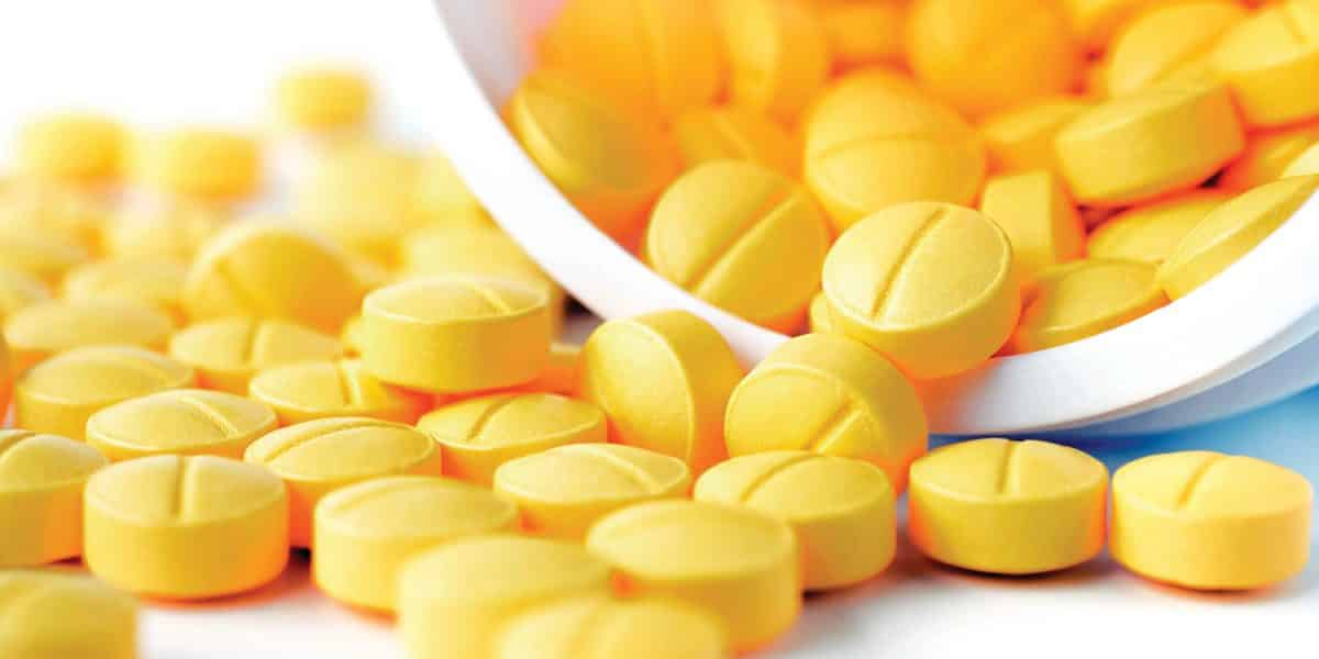 Yellow dilaudid pills spilling out of a prescription bottle