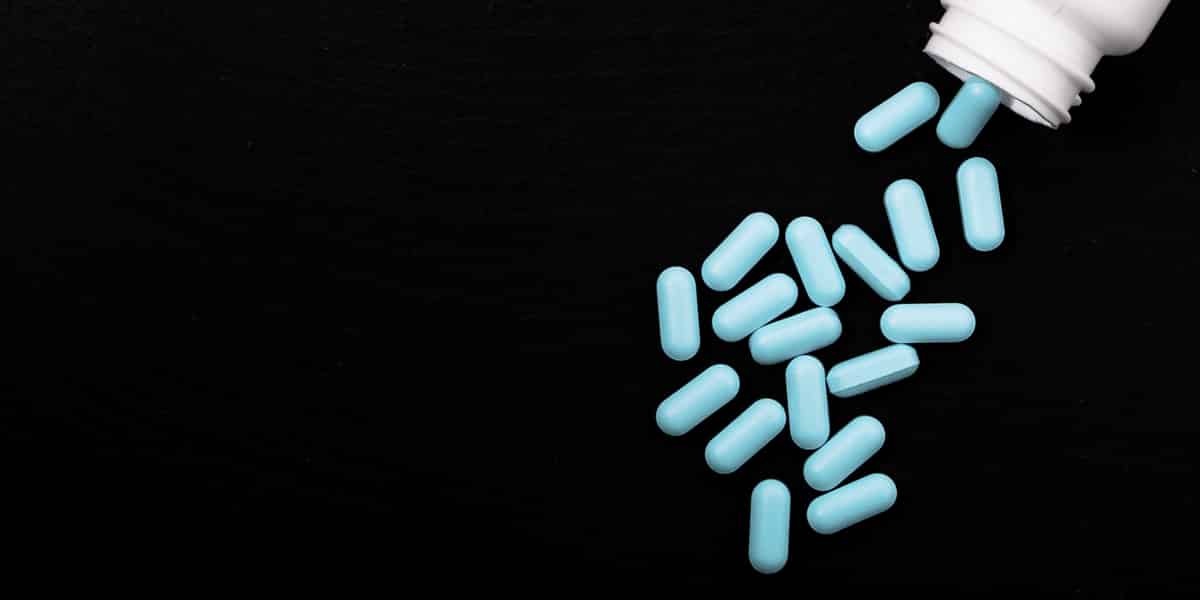 Blue fioricet pills falling out of a prescription bottle