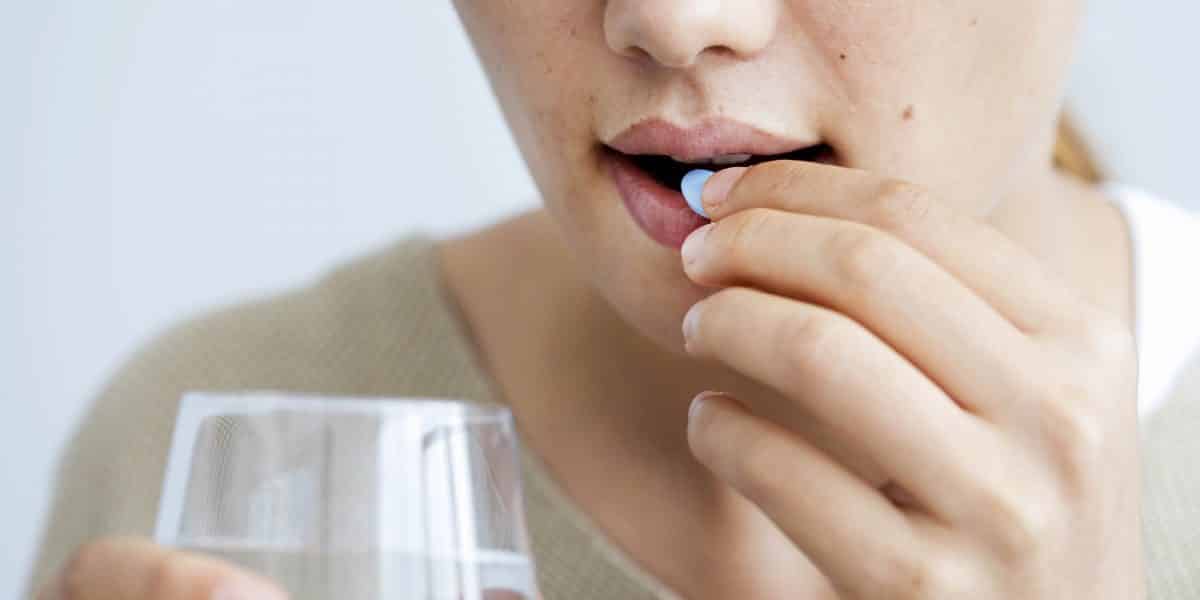 Woman about to take klonopin pill with a glass of water