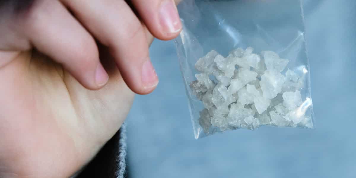 person holding  a bag of crystal meth