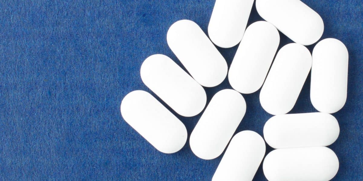 Methadone pills sitting on a blue carpet