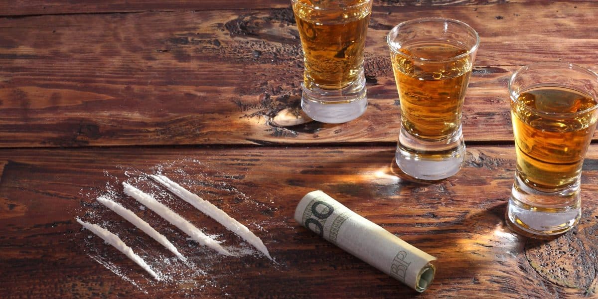lines of cocaine next to several shot glasses