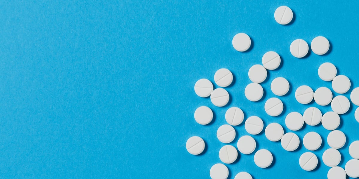 white dilaudid pills on blue background