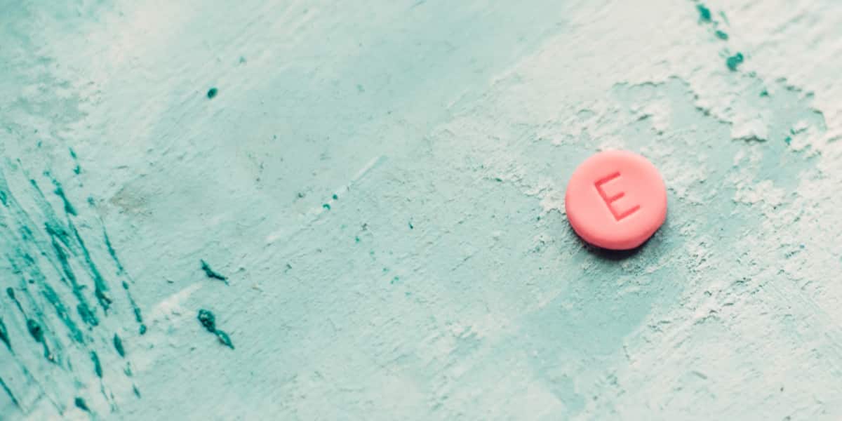 Pink ecstasy pill sitting on a painted wood counter