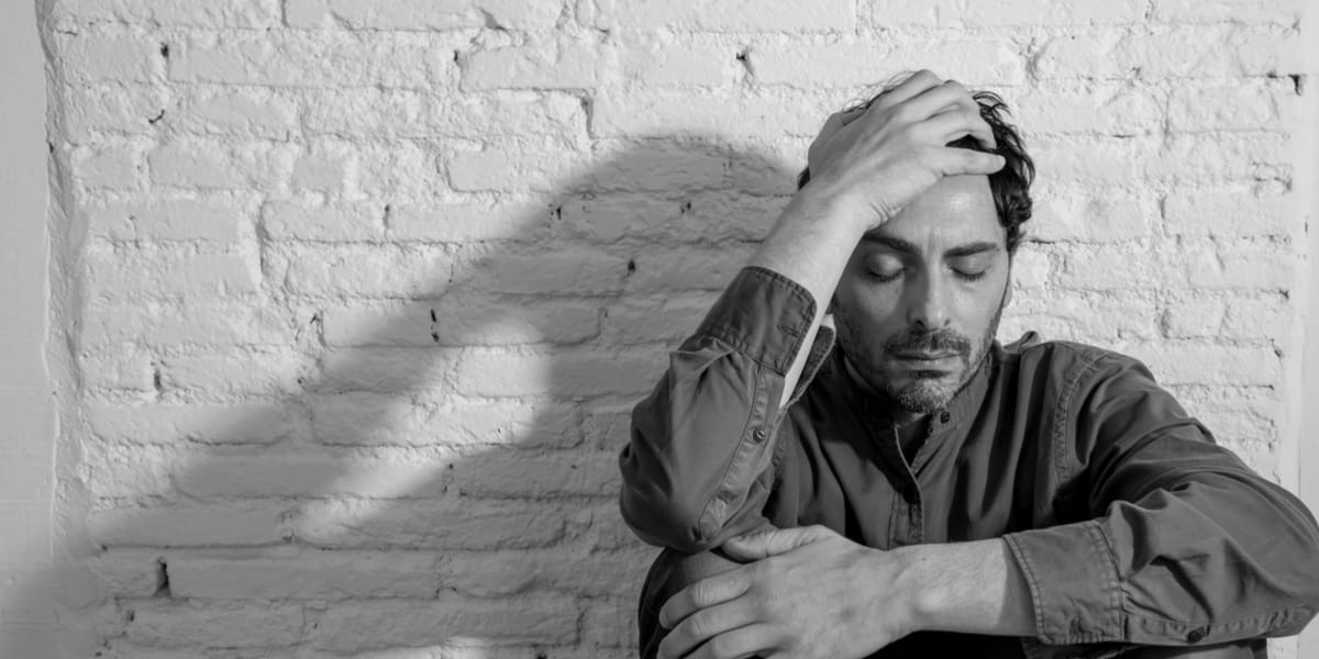 Man experiencing a headache while he is tapering off benzos