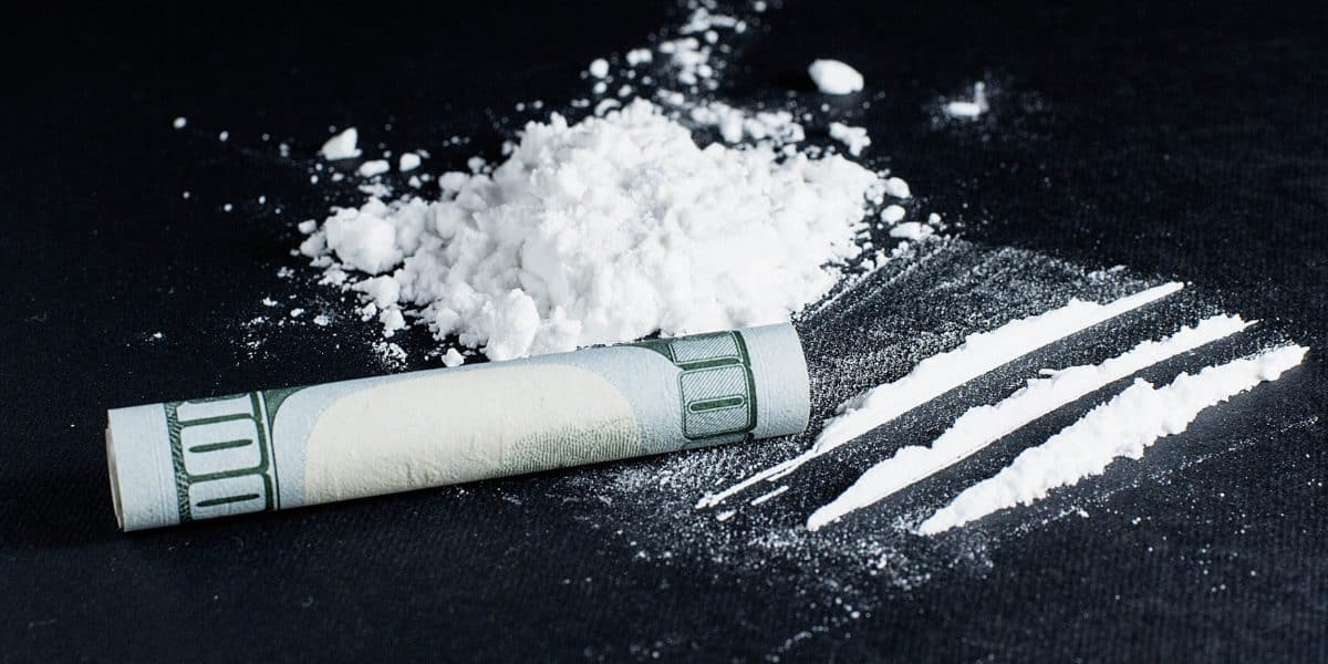 Pile of cocaine next to rolled up dollar bill